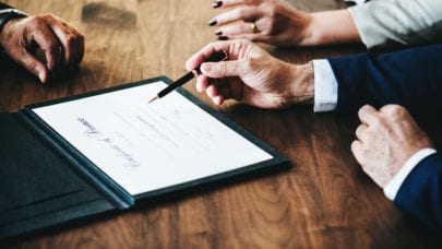 The hands of lawyers looking over a document meant to represent Louisiana statutes of limitations.