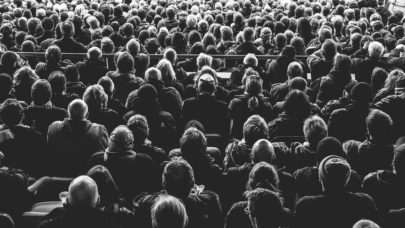 A black and white photo of a crowd of individuals staring away from the camera. This photo is meant to represent the article "What are Class-action Lawsuits?" by MMRBH Law Office.