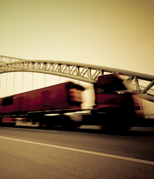 a high-speed truck zooms down the highway, representing MMRBH Law Office's trucking accident legal services.